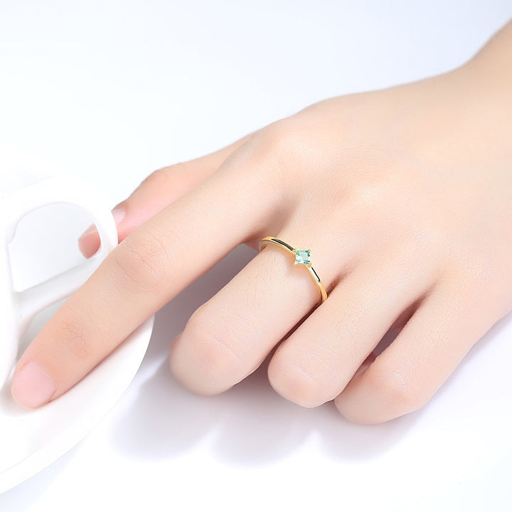 emerald solitaire rings worn on hand