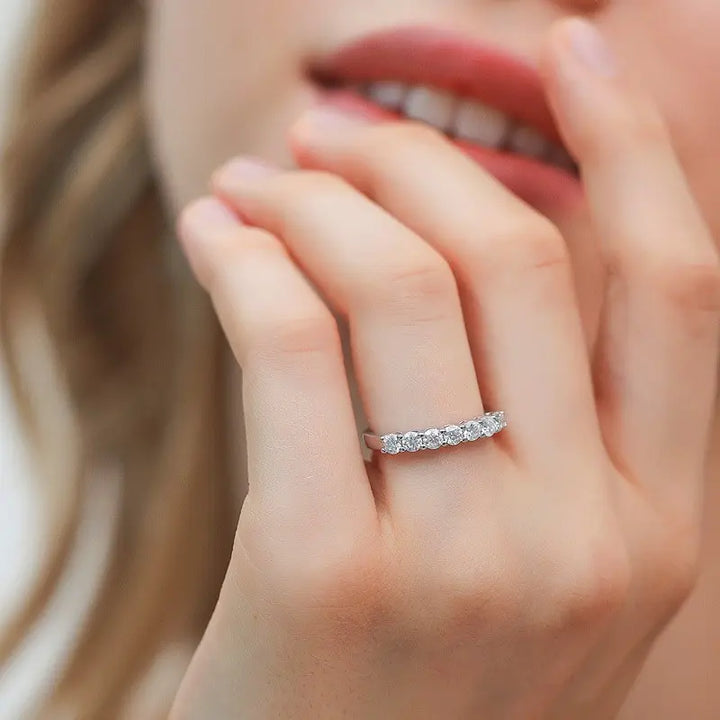 seven round cut sterling silver moissanite wedding band ring worn on hand